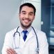 smiling-doctor-with-stethoscope-at-hospital-PVS8FJU